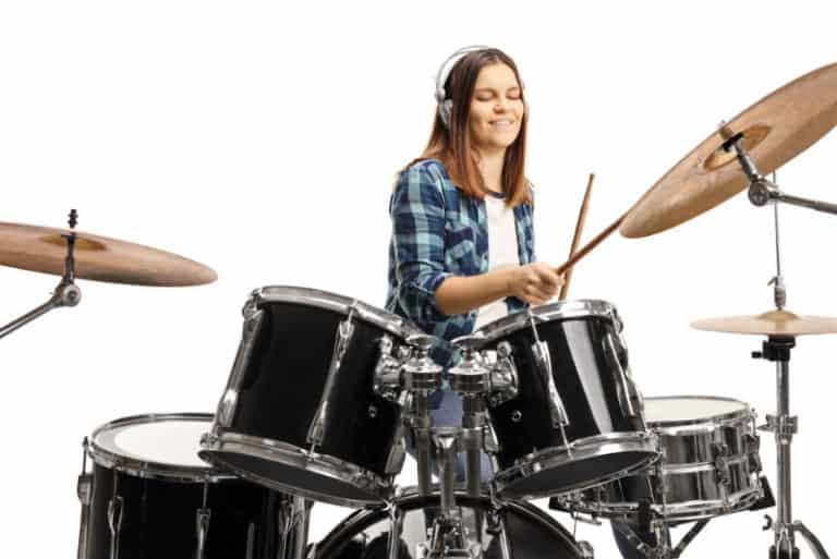 girl drumming with headphones